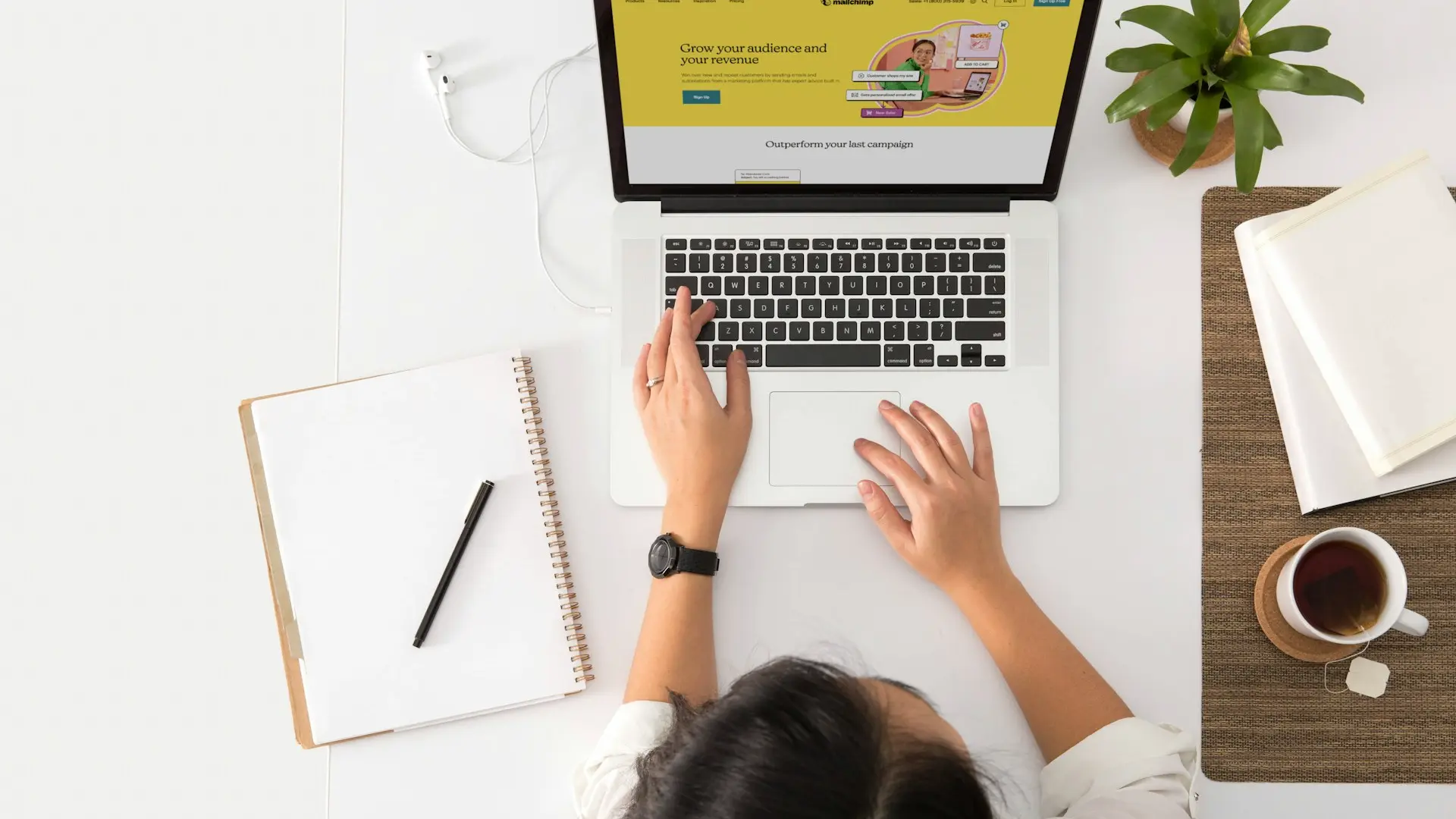 a person sitting at a desk with a laptop and a coffee cup